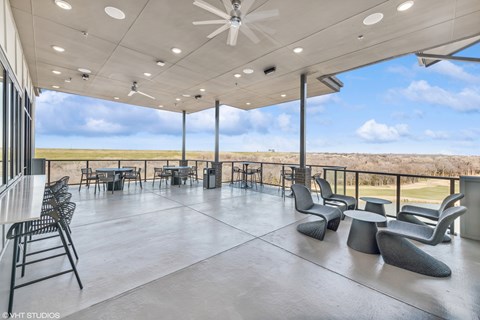 A spacious room with a ceiling fan and multiple chairs and tables.