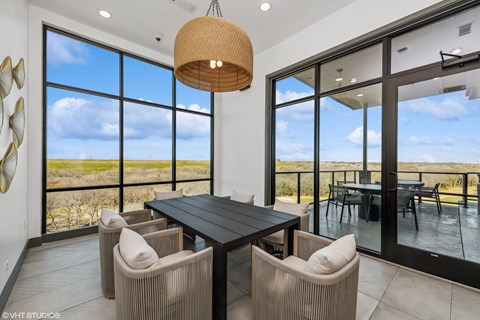 A modern dining room with a large table and chairs.