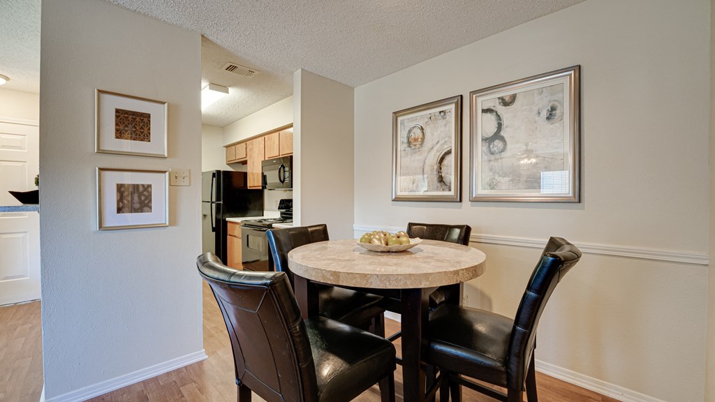a dining area with a table and chairs and a kitchen at Paces Crossing, Denton, Texas