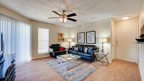 a living room with leather furniture and a ceiling fan at Paces Crossing, Denton, Texas