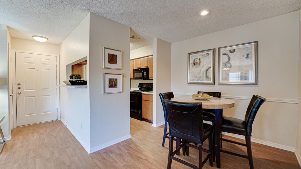 a dining area with a table and chairs and a kitchen at Paces Crossing, Denton