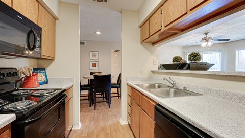 the view of a kitchen with a sink and a stove and a dining room area