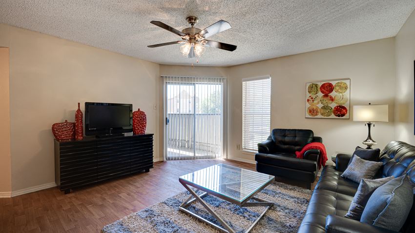 a living room with leather furniture and a glass coffee table