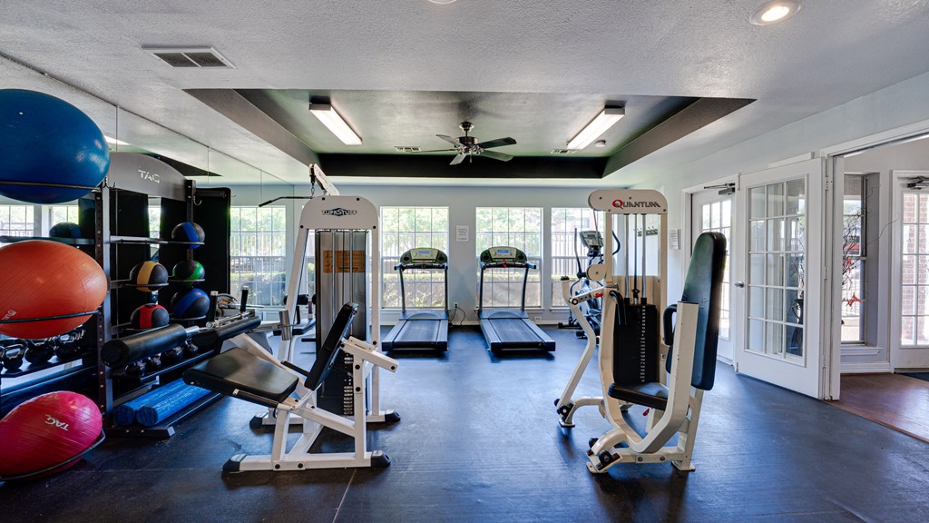 a gym with weights and cardio equipment and windows at Paces Crossing, Denton, 76210