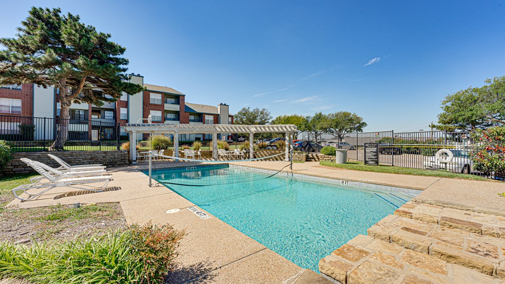 our apartments offer a swimming pool with a gazebo and chairs at Paces Crossing, Texas
