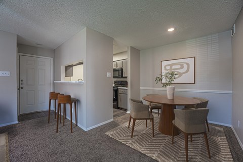 A dining room with a table and chairs.