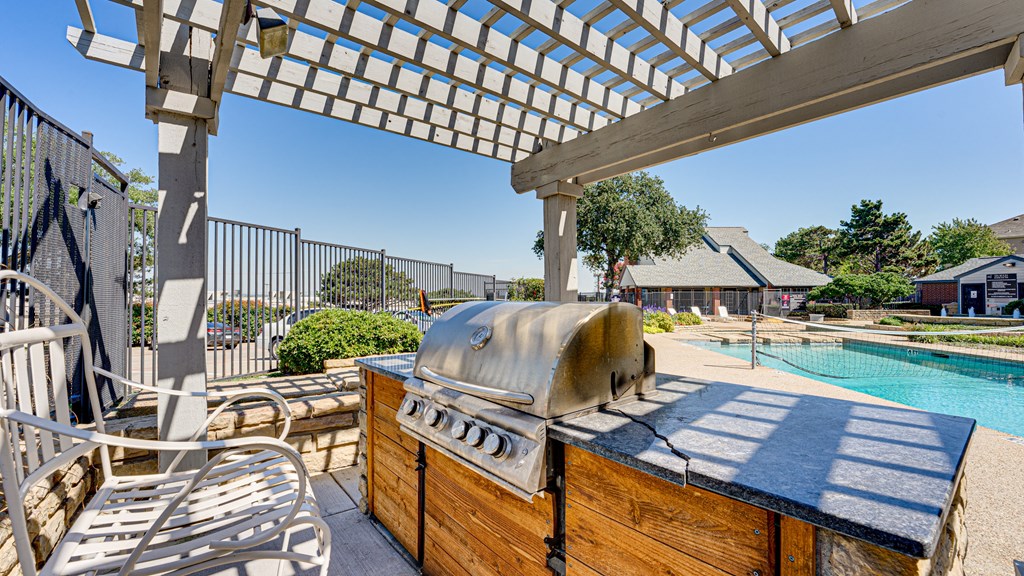 a patio with a grill and a swimming pool at Paces Crossing, Denton, Texas