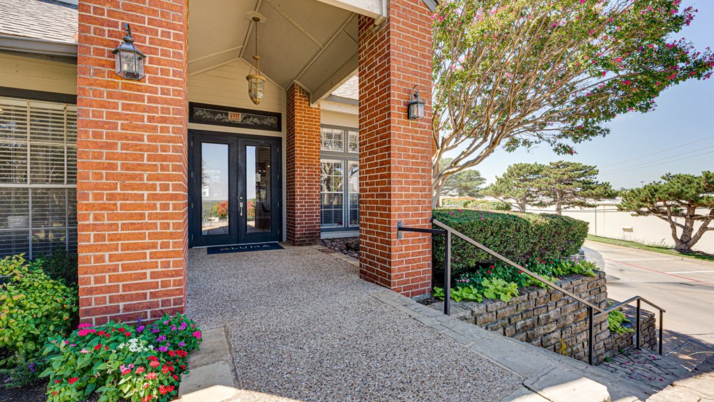 the entrance to a brick building with a glass door at Paces Crossing, Denton, TX