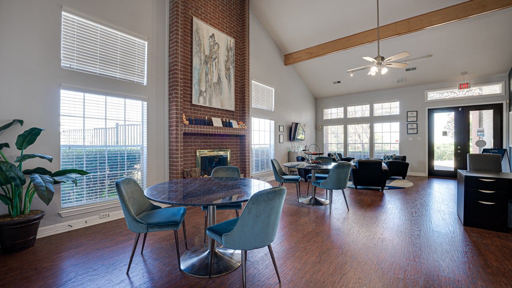 a living room with a table and chairs and a brick fireplace at Paces Crossing, Denton, Texas