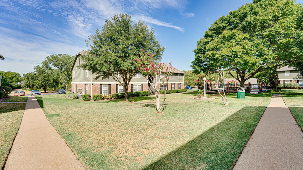 courtyard space with green grass and building exteriors courtyard space with green grass and building exteriors at Arbors Of Cleburne, Cleburne, 76033
