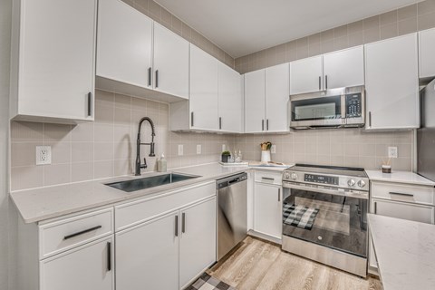 A kitchen with white cabinets and stainless steel appliances.