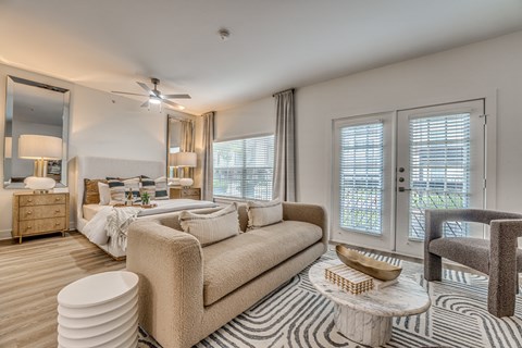 Spacious bedroom suite with sitting area and patio access at The Bowen on Henderson Apartments, Texas