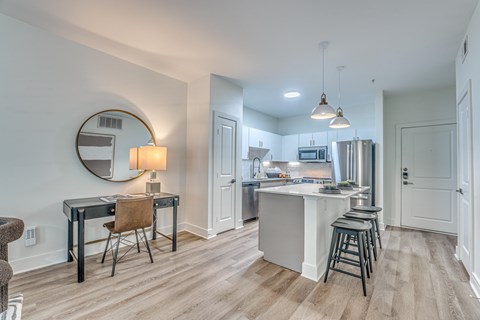 A kitchen with a bar stool and a table with a chair.