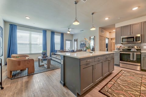 A modern kitchen with a large island and a dining area.