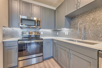 A modern kitchen with a stove top oven and microwave.