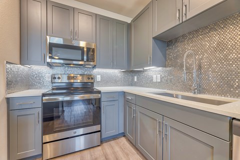 A modern kitchen with a stove top oven and microwave.