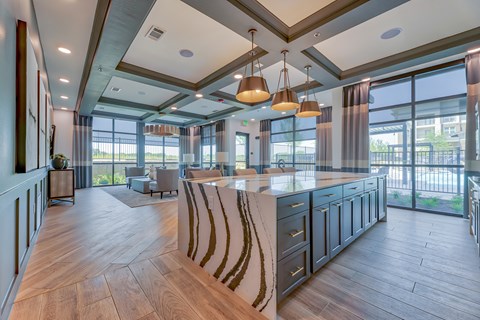 A modern kitchen with a large island and pendant lights.