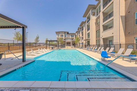 A swimming pool in front of apartment buildings.