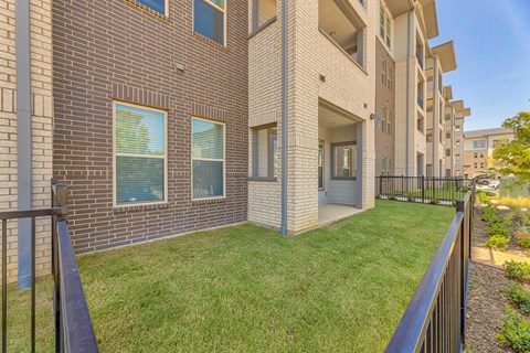 A brick building with a green lawn in front.