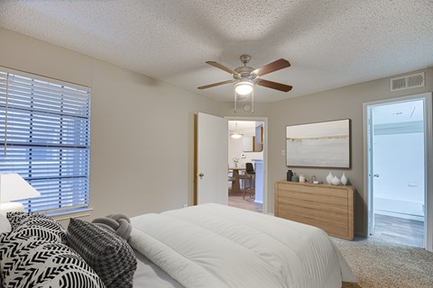 A bedroom with a large bed and a ceiling fan.