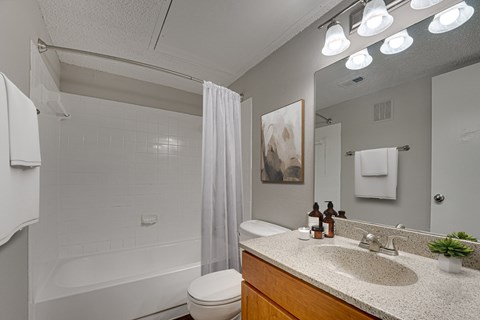 A bathroom with a white toilet, a white sink, and a white bathtub.