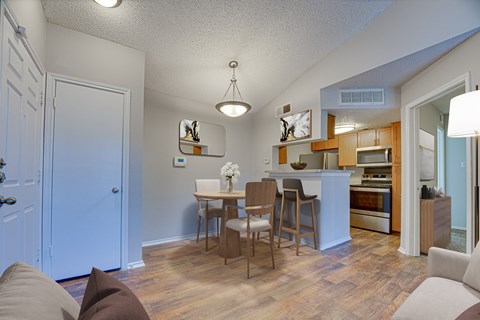 A kitchen with a dining table and chairs.