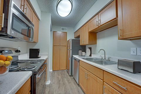 A kitchen with wooden cabinets and a stove top oven.
