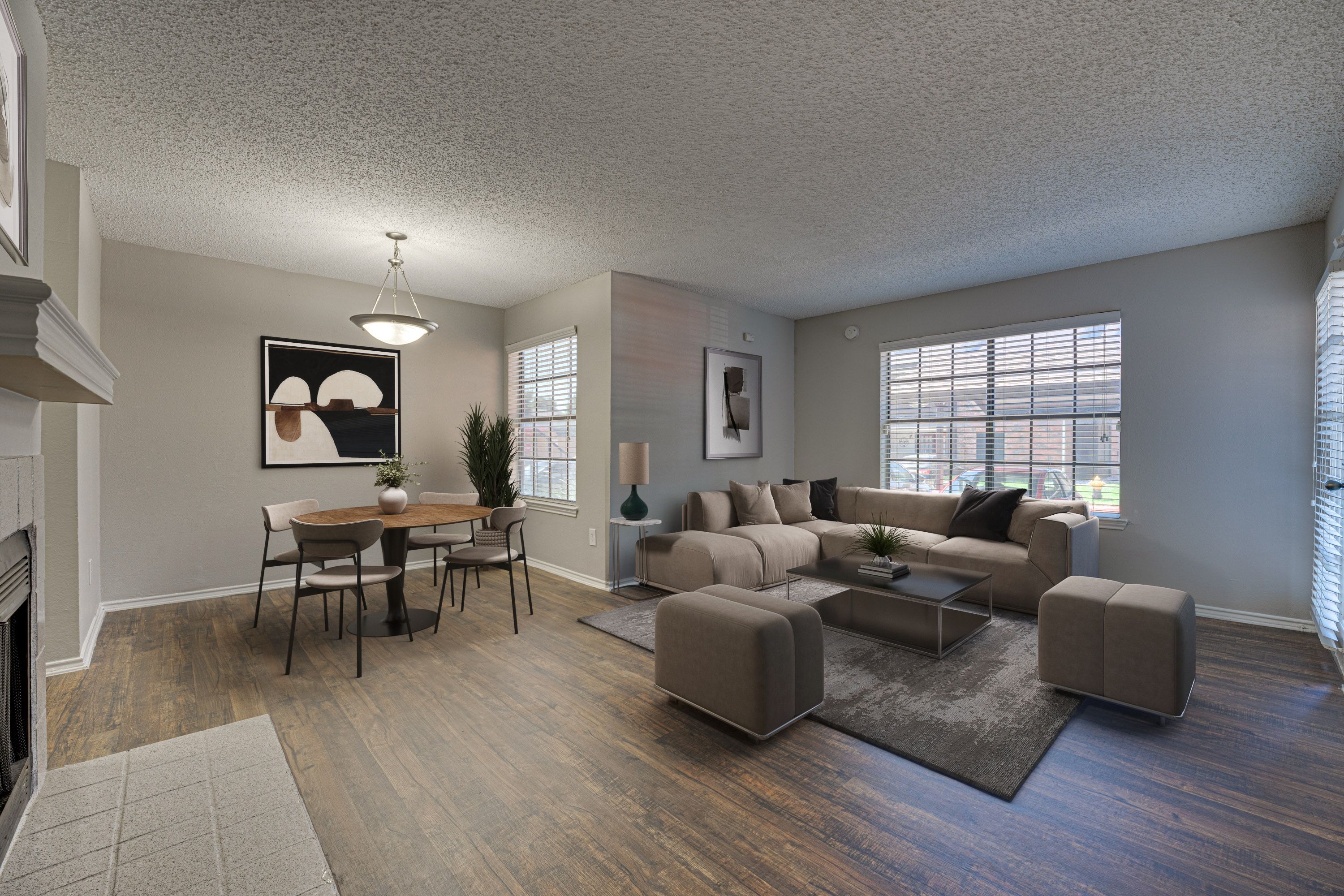 A living room with a grey couch, a coffee table, and a dining table with chairs.