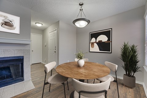 A dining room with a wooden table and chairs.