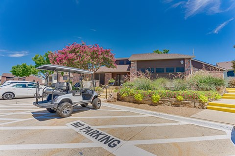 A golf cart is parked in a no parking zone.