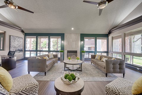 A living room with a grey couch, a coffee table, and a ceiling fan.