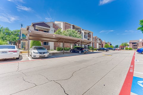A parking lot with cars and a building in the background.