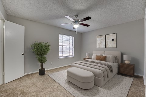A bedroom with a large bed and a ceiling fan.