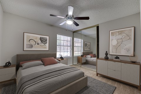 A bedroom with a large bed and a ceiling fan.