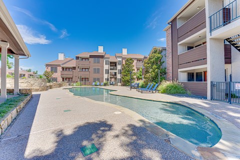A swimming pool in a residential area surrounded by buildings.