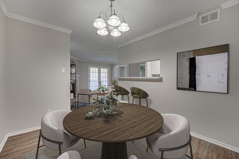 A dining room with a round table and chairs.