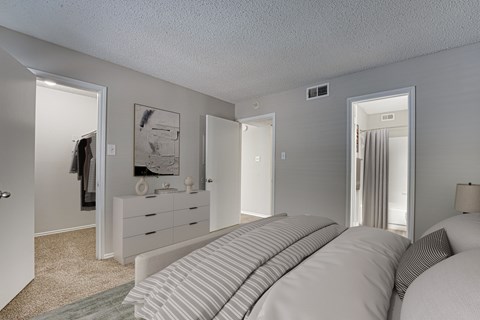 A bedroom with a large bed and a dresser with a mirror.