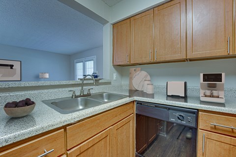 A kitchen with wooden cabinets and a granite countertop.