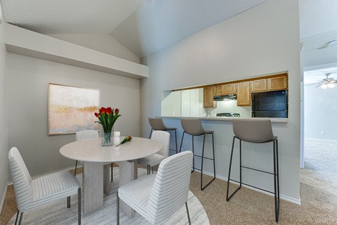 A dining room with a white table and chairs.