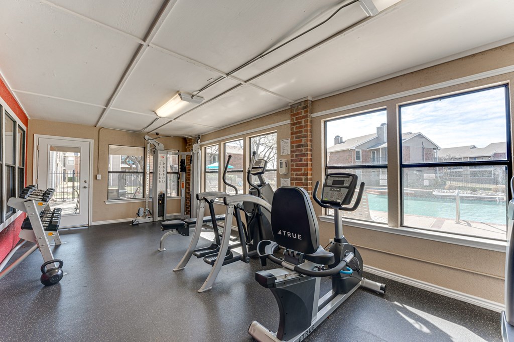 A gym with a row of exercise bikes and a treadmill. at Towne Centre Village, Texas, 75150