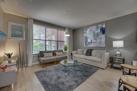 A living room with a couch, a coffee table, and a large painting on the wall.