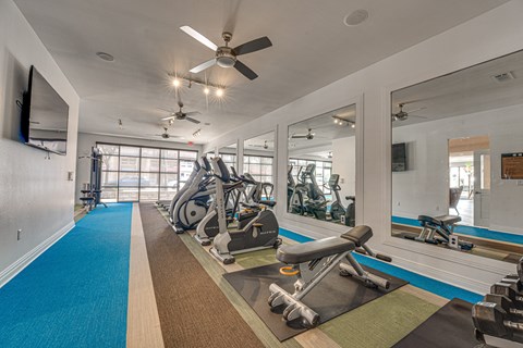 Fitness center with cardio equipment and mirrors at Vue Live Oak Apartments, Texas, 75204