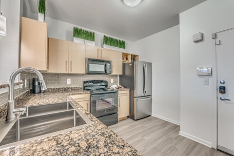 A kitchen with a stove top oven, microwave, and refrigerator.