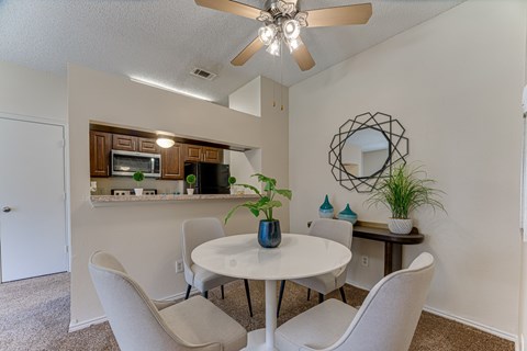A dining room with a white table and chairs.