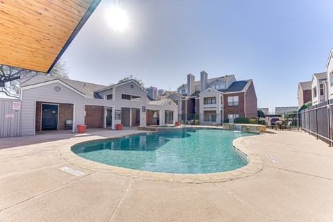 A swimming pool in a residential area with houses in the background.