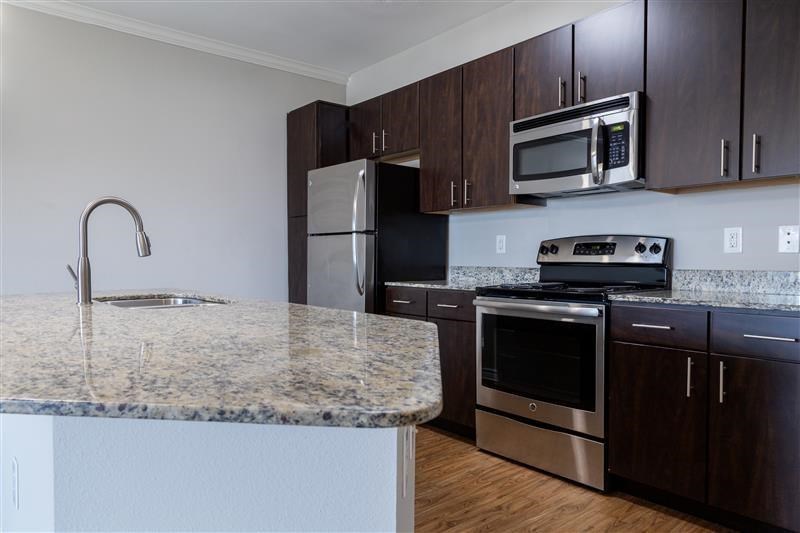 A kitchen with granite countertops and stainless steel appliances.