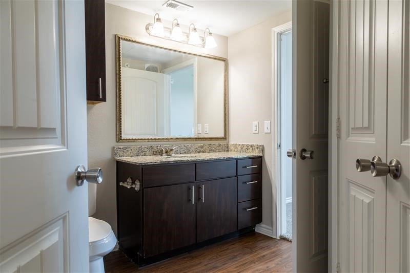 A bathroom with a marble countertop and a large mirror.