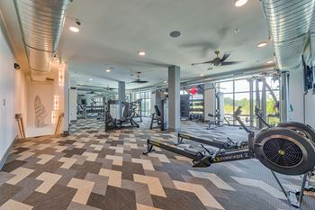 A room with a treadmill and a fan.
