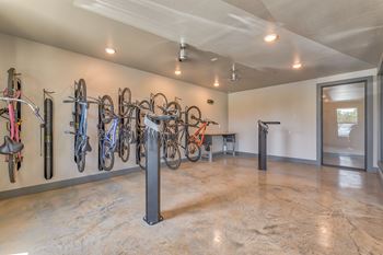 A room with a wall of bicycles and a bench.
