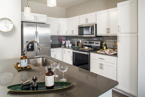 a kitchen with white cabinets and stainless steel appliances